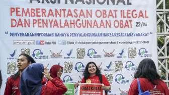 Petugas Balai POM melakukan kampanye jenis makanan dan obat-obatan dalam acara Aksi Nasional Pemberantasan Obat Ilegal dan Penyalahgunan Obat kepada para pengunjung di kawasan Car Free Day (CFD), Jakarta, Minggu (22/10/2017). [Suara.com/Kurniawan Mas'ud]