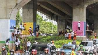 Siswa Sekolah Menengah Kejuruan (SMK) menyelesaikan proyek pembuatan mural di tiang penyangga jalan layang non tol (JLNT) Kasablanka, Jakarta, Jumat (1/12).