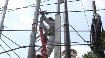 Petugas merapikan kabel di kawasan Gambir, Jakarta, Kamis (7/12).