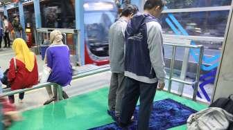 Calon penumpang Transjakarta melaksanakan salat Zuhur di Halte Transjakarta, Karet, Jalan Sudirman, Jakarta Pusat, Sabtu (9/12).