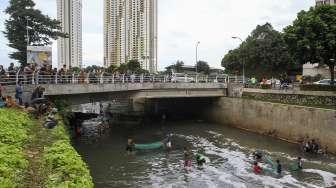 Sejumlah warga berebut mencari ikan di kali kawasan Epicentrum, Kuningan, Jakarta, Rabu (13/12).