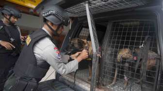 Anggota polisi unit K-9 berjaga di Terminal Domestik saat dimulainya posko terpadu untuk liburan Natal dan Tahun Baru 2018 di Bandara Ngurah Rai, Bali, Senin (18/12).