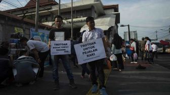 Koalisi Pejalan Kaki melakukan aksi Tamasya Trotoar Tanah Abang Jalan Jatibaru Raya, Jakarta, Jumat (29/12).