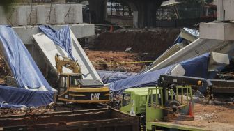 Pekerja dengan menggunakan alat berat melakukan evakuasi girder proyek pembangunan tol Antasari-Depok yang roboh di Jalan Pangeran Antasari, Cilandak, Jakarta, Jumat (5/1). 