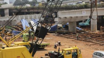 Pekerja dengan menggunakan alat berat melakukan evakuasi girder proyek pembangunan tol Antasari-Depok yang roboh di Jalan Pangeran Antasari, Cilandak, Jakarta, Jumat (5/1). 