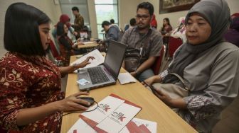 Petugas melayani pemohon Sistem Layanan Informasi Keuangan (SLIK) di kantor Otoritas Jasa Keuangan (OJK), Jakarta, Senin (8/1).