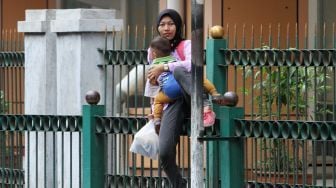 Sejumlah penumpang melompati pagar pembatas di Stasiun Cikini, Jakarta, Senin (8/1). 