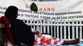 Sejumlah Warga Negara Asing (WNA) beraktivitas di atas trotoar depan Rumah Detensi Imigrasi, Jalan Peta Selatan, Kalideres, Jakarta Barat, Kamis (11/1). 