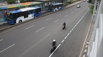 Pengendara sepeda motor melintasi Jalan MH Thamrin, Jakarta, Jumat (12/1).