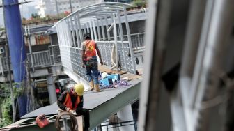 Pekerja menyelesaikan pembangunan jembatan penyeberangan orang (JPO) di Halte Kuningan Timur, Jakarta Selatan, Sabtu (13/1).