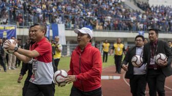 Menteri Pemuda dan Olahraga Imam Nahrowi (tengah) bersama Ketua Pelaksana Piala Presiden Berlinton Siahaan (kiri) membagikan bola bertandatangan Presiden Joko Widodo ke Suporter pada pembukaan Piala Presiden 2018 di Stadion Gelora Bandung Lautan Api, Bandung, Jawa Barat, Selasa (16/1). 