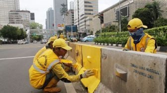 Petugas Dinas Bina Marga DKI Jakarta mengecat Movable Concrete Barrier (MCB) di jalur Transjakarta di kawasan Jalan MH Thamrin, Jakarta, Sabtu (20/1). 