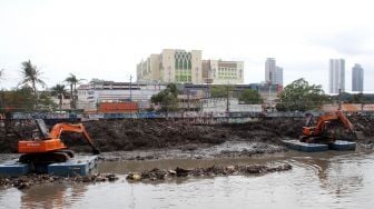 Pengerukan endapan sampah yang bercampur lumpur di aliran Kali Ciliwung, Kanal Banjir Barat, Jakarta, Selasa (20/1). 