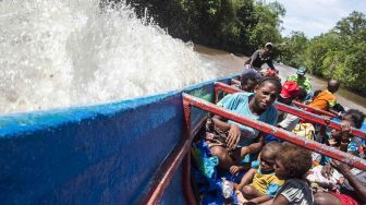 Warga dan anak-anak pasien gizi buruk dan campak usai menjalani pemeriksaan dan perawatan kesehatan di RSUD Agats, menuju Distrik Jetsy di Kabupaten Asmat, Papua, Selasa (23/1). 