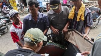 Sejumlah tukang becak melakukan pendataan identitas kepada petugas Kelurahan di kawasan kolong flyover Bandengan, Jakarta, Sabtu (27/1).