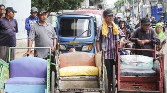 Sejumlah tukang becak melakukan pendataan identitas kepada petugas Kelurahan di kawasan kolong flyover Bandengan, Jakarta, Sabtu (27/1).