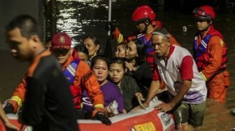 Petugas Damkar melakukan evakuasi dengan perahu karet terhadap korban banjir di kawasan Pejaten Timur, Pasar Minggu, Jakarta, Senin (5/2). 