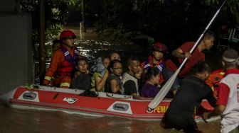 Petugas Damkar melakukan evakuasi dengan perahu karet terhadap korban banjir di kawasan Pejaten Timur, Pasar Minggu, Jakarta, Senin (5/2). 