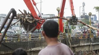 Dinas Lingkungan Hidup DKI Jakarta membersihkan sampah-sampah yang menumpuk di Jembatan KH Abdulah Syafe'i, Kampung Melayu, Jakarta, Rabu (7/2). 