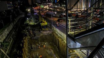 Sejumlah kendaraan melintas di samping lokasi proyek pembangunan Light Rail Transit (LRT) di Jalan Gatot Subroto, Jakarta (6/2) malam. 