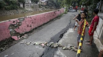 Jalan retak di area permukiman warga di jalan Kesatriaan IX, Berlan, Matraman, Jakarta, Selasa (13/2).