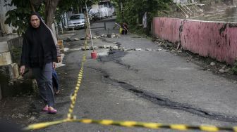 Jalan retak di area permukiman warga di jalan Kesatriaan IX, Berlan, Matraman, Jakarta, Selasa (13/2).