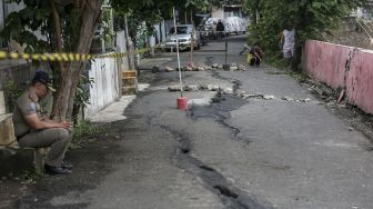 Jalan retak di area permukiman warga di jalan Kesatriaan IX, Berlan, Matraman, Jakarta, Selasa (13/2).