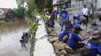 Petugas Sudin Bina Marga dan Sudin Tata Air dan PPSU melakukan pemasangan bronjong kawat di lokasi terjadinya jalan retak sepanjang 50 meter di Kampung Berlan, Matraman, Jakarta, Rabu (14/2).