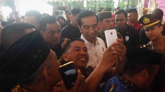 Presiden Joko Widodo (tengah) berfoto bersama warga seusai penyerahan secara simbolik Kartu Program Keluarga Harapan (PKH) dan Kartu Indonesia Pintar (KIP) di Lapangan Syech Yusuf, Kabupaten Gowa, Sulawesi Selatan, Kamis (15/2). 