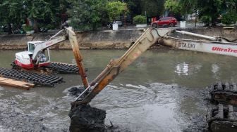 Pengerukan lumpur di aliran anak kali Ciliwung, Pasar Baru, Jakarta, Senin (19/2). 