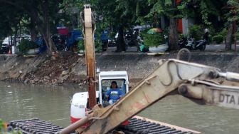 Pengerukan lumpur di aliran anak kali Ciliwung, Pasar Baru, Jakarta, Senin (19/2). 