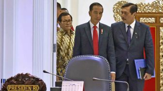 Presiden Joko Widodo (tengah) berbincang dengan Menko Kemaritiman Luhut Panjaitan (kanan) dan Seskab Pramono Anung sebelum memimpin rapat terbatas tentang insentif investasi di Kantor Presiden, Jakarta, Selasa (20/2).