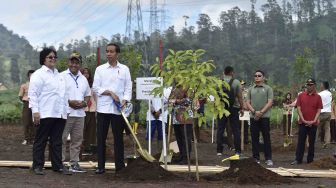 Presiden Joko Widodo didampingi Menteri Lingkungan Hidup dan Kehutanan Siti Nurbaya (kiri) dan Dirut PTPN VIII Bagya Mulyanto (kedua kiri) menanam pohon Manglid di kawasan Hulu Sungai Citarum, Kertasari, Kabupaten Bandung, Jawa Barat, Kamis (22/2). 