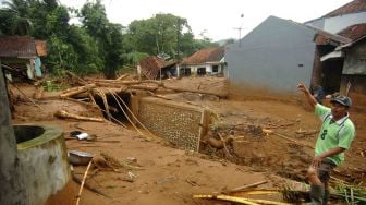 Seorang warga memperhatikan pemukiman yang terkena banjir material longsor di Desa Pasirpanjang, Salem, Brebes, Jawa Tengah, Jumat (23/2). 