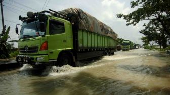 Sejumlah kendaraan melintas di genangan banjir di jalur Pantura Losari, Brebes, Jawa Tengah, Sabtu (24/2). 