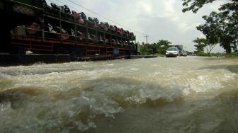 Sejumlah kendaraan melintas di genangan banjir di jalur Pantura Losari, Brebes, Jawa Tengah, Sabtu (24/2). 