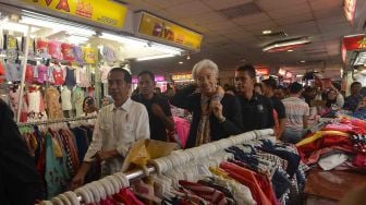 Presiden Joko Widodo (kiri) besama Direktur Pelaksana Dana Moneter Internasional (IMF) Christine Lagarde (ketiga kiri) melakukan blusukan ke Pasar Tanah Abang Jakarta, Senin (26/2). 