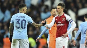 Pemain Man City Nicolas Otamendi (kiri) berjabat tangan dengan pemain Arsenal Laurent Koscielny [AFP]