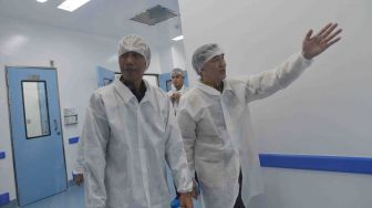 Presiden Joko Widodo (kiri) mendengarkan penjelasan Presiden Direktur PT Kalbe Farma Tbk Vidjongtius ketika meninjau fasilitas produksi di sela-sela peresmian pabrik bahan baku obat dan produk biologi PT Kalbio Global Medika yang merupakan anak usaha dari PT Kalbe Farma, di Cikarang, Kabupaten Bekasi, Jawa Barat, Selasa (27/2).