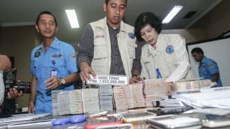 Petugas Badan Narkotika Nasional (BNN) saat menata dan menunjukkan barang bukti hasil pengungkapan kasus tindak pidana pencucian uang (TPPU) dari kasus narkotika di Jakarta, Rabu (28/2/2018). [Suara.com/Kurniawan Mas'ud]