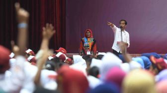 Presiden Joko Widodo (kanan) mengajukan pertanyaan kepada siswa saat penyerahan Kartu Indonesia Pintar dan Program Keluarga Harapan di Gor Tri Dharma, Gresik, Jawa Timur, Kamis (8/3). 