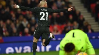 Gelandang Manchester David Silva merayakan golnya usai menaklukkan kiper Stoke City Jack Butland (kanan). Paul ELLIS / AFP
