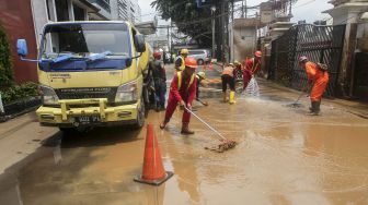 Sejumlah pekerja membersihkan sisa semburan lumpur gas PGN yang bocor di halaman kantor Badan Narkotika Nasional (BNN) di Cawang, Jakarta, Selasa (13/2). 