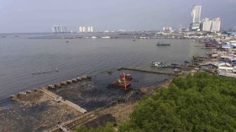 Alat berat dioperasikan untuk membersihkan sampah di kawasan Hutan Mangrove, Muara Angke, Jakarta, Selasa (20/3).