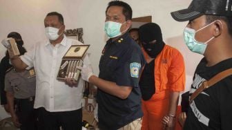 Polisi menunjukkan cerutu yang akan dicampur tembakau gorilla saat penggerebekan pabrik ganja sintetis tersebut di Denpasar, Bali, Kamis (22/3). 