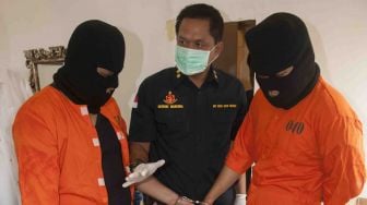 Polisi memeriksa tersangka dan barang bukti bahan tembakau gorilla saat penggerebekan pabrik ganja sintetis tersebut di Denpasar, Bali, Kamis (22/3).