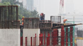 Pekerja menyelesaikan pembangunan proyek kereta ringan atau light rail transit Jakarta-Bogor-Depok-Bekasi (LRT Jabodebek) di kawasan Kuningan, Jakarta, Jumat (24/3/2018). [Suara.com/Oke Atmaja]