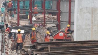 Pekerja menyelesaikan pembangunan proyek kereta ringan atau light rail transit Jakarta-Bogor-Depok-Bekasi (LRT Jabodebek) di kawasan Kuningan, Jakarta, Jumat (24/3/2018). [Suara.com/Oke Atmaja]