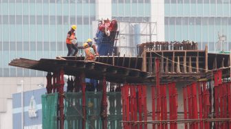 Pekerja menyelesaikan pembangunan proyek kereta ringan atau light rail transit Jakarta-Bogor-Depok-Bekasi (LRT Jabodebek) di kawasan Kuningan, Jakarta, Jumat (24/3/2018). [Suara.com/Oke Atmaja]