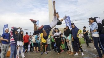 Permainan tradisional yang populer di masyarakat Indonesia terancam punah, tergeser oleh permainan digital. Sejumlah anak dan orangtua ini kembali menunjukkan permainan itu di Silang Monas. (Suara.com/Kurniawan Mas'ud)